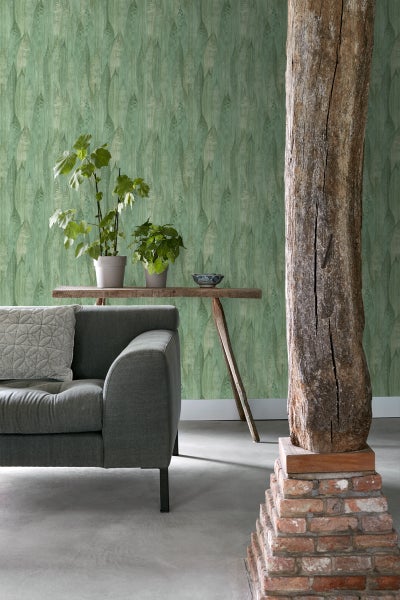 Wohnzimmer mit gemusterter Tapete, Sofa, Holztisch und Zimmerpflanzen