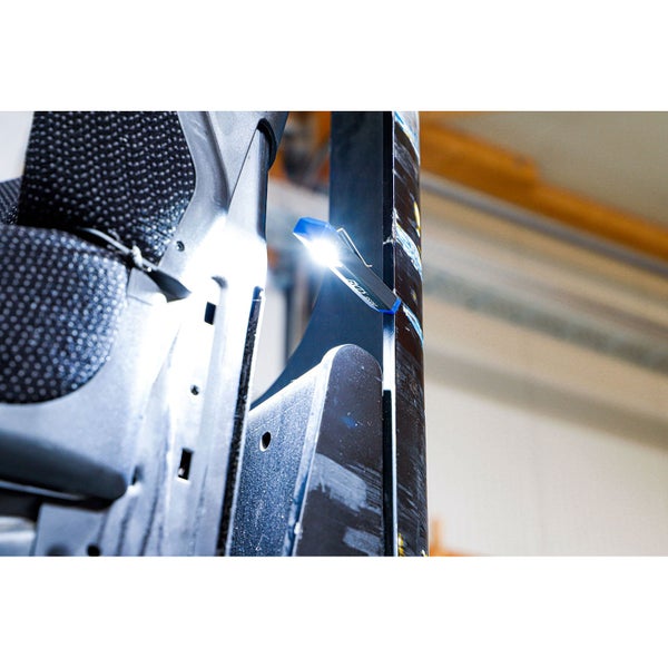 Kleine LED-Arbeitsleuchte mit Clip an einer Metallkonstruktion befestigt, helles Licht.