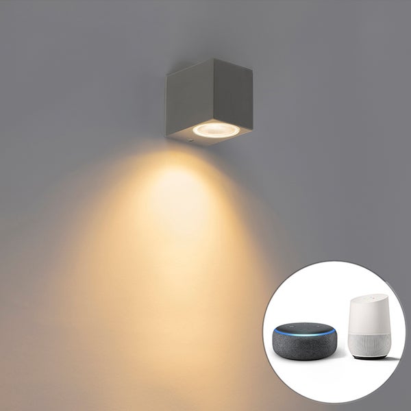 Graue Wandleuchte in Würfelform mit Lichtaustritt nach unten. Kompatibel mit Smart Home Systemen wie Amazon Alexa und Google Home.