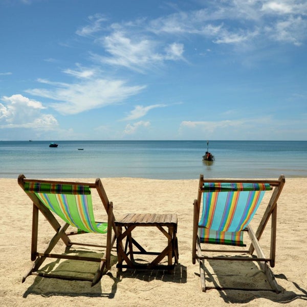 Zwei Strandstühle mit kleinem Tisch am Sandstrand