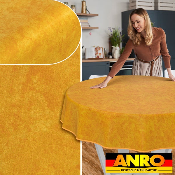 Gelbe Wachstuch-Tischdecke auf einem runden Tisch, mit einer Frau im Hintergrund und dem Anro Logo.