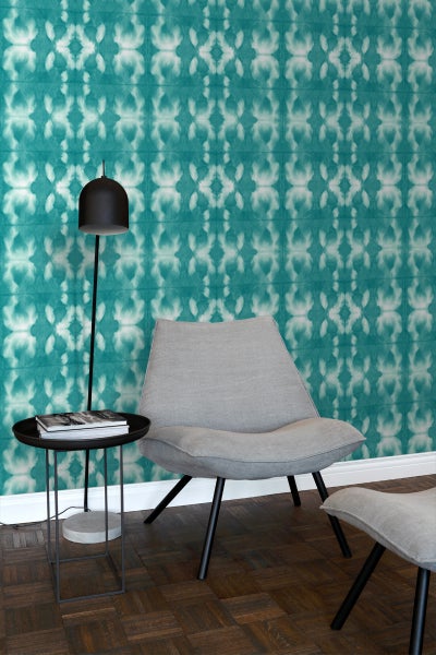 Wohnzimmer mit gemusterter Tapete, Sessel und Stehlampe