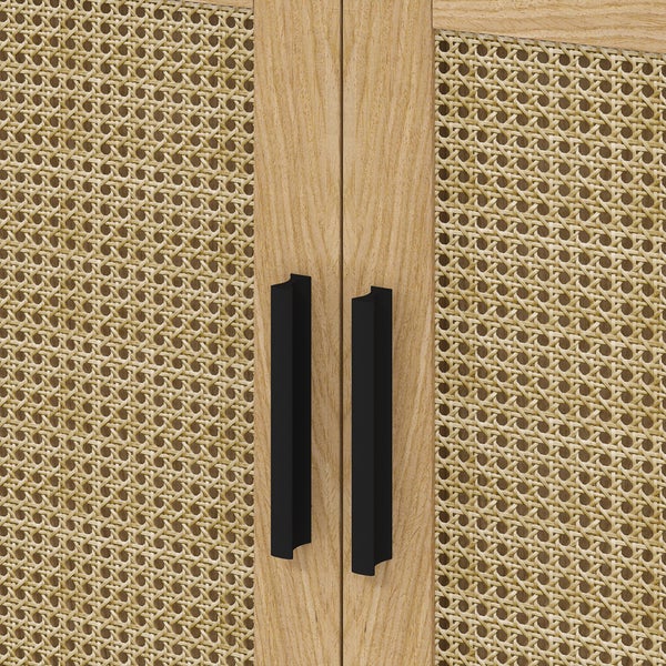 Nahaufnahme einer Schranktür mit Wiener Geflecht, hellem Holzrahmen und zwei schwarzen Metallgriffen.