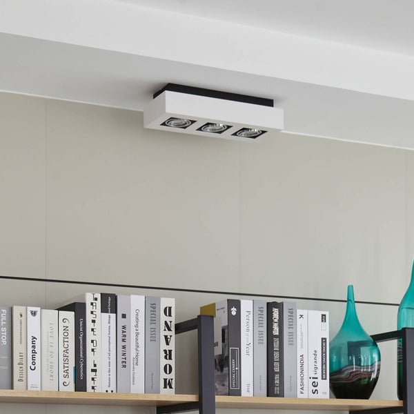 Deckenleuchte mit drei Strahlern über einem Bücherregal