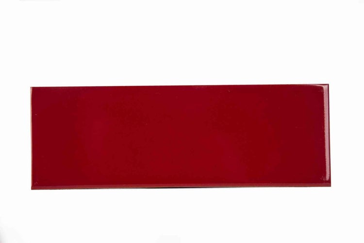 Rote, rechteckige Wandfliese aus Keramik mit glänzender Oberfläche.