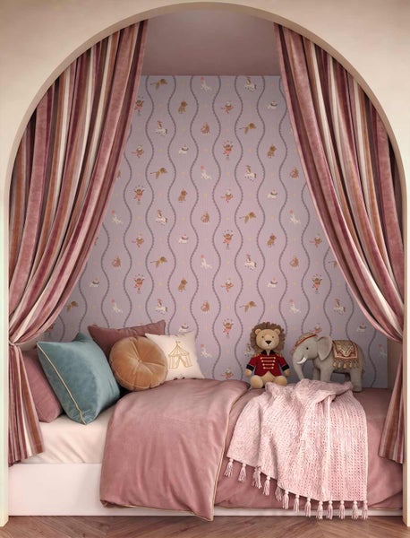 Kinderzimmer-Nische mit Zirkus-Tapete, gestreiften Vorhängen, Bett mit rosa Bettwäsche, Kissen sowie Löwen- und Elefanten-Stofftieren.