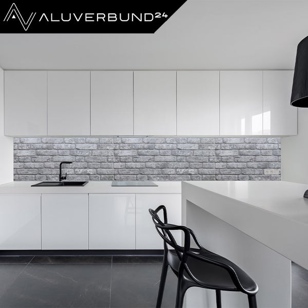 Helle Küche mit einer Küchenrückwand in Steinoptik und dem Aluverbund24 Logo.