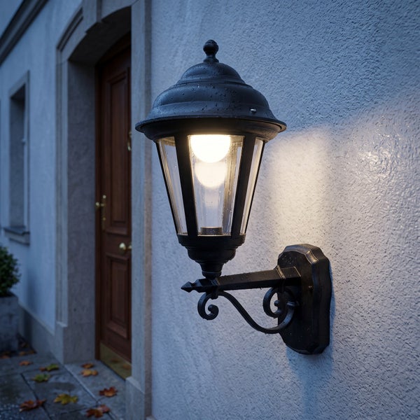 Klassische Wandleuchte für den Außenbereich in Laternenform an einer Hausfassade montiert.