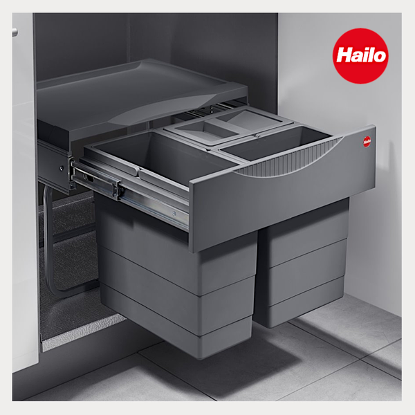 Ausziehbares Hailo Mülltrennsystem für Küchenunterschränke mit zwei Abfallbehältern und Ablageschale auf Metallschienen. Hailo Logo.