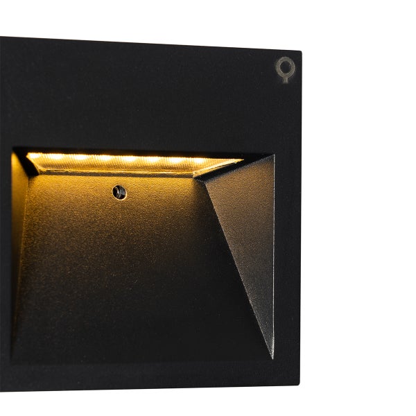 Quadratische LED-Wandeinbauleuchte in Schwarz mit warmweißem Lichtaustritt aus einer Vertiefung.