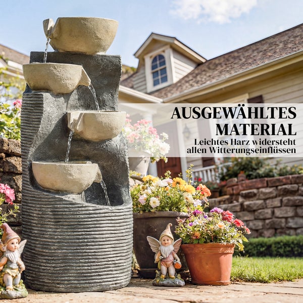 Etagen-Gartenbrunnen aus wetterfestem Harz in Steinoptik, umgeben von Blumentöpfen und Gartenzwergen in einem sonnigen Garten.