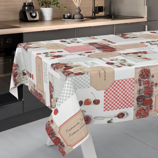Tischdecke in einer hellen, organisierten Küche mit einem Muster aus Früchten wie Erdbeeren und Kirschen, Marmeladengläsern und Karomuster.
