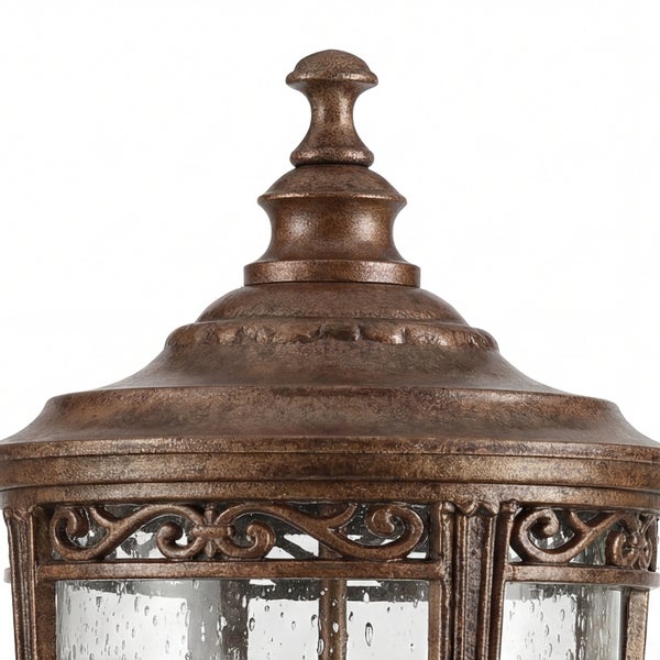 Detailaufnahme einer bronzefarbenen Aussenleuchte mit Ornamenten und klarem Glas