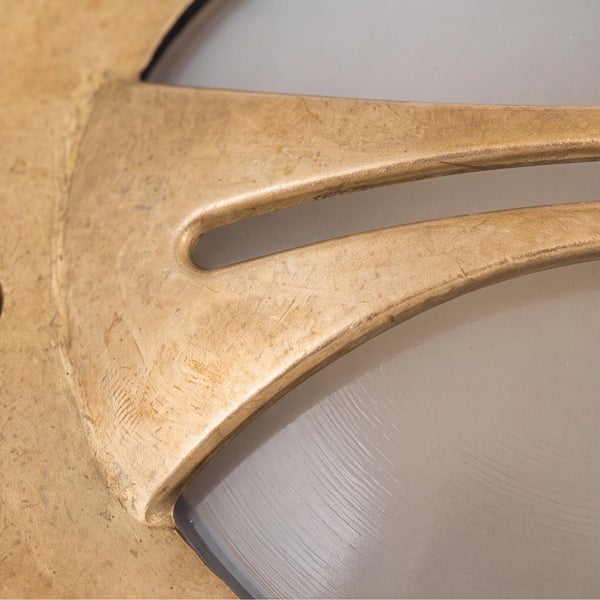 Nahaufnahme einer Leuchte mit strukturierter Metalloberfläche und mattiertem Glas.
