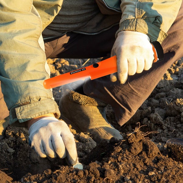 Person mit Metallsuchstift beim Suchen im Boden