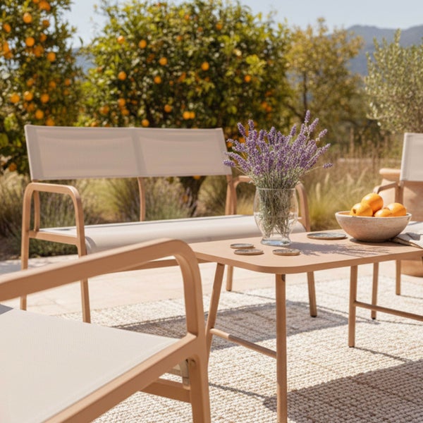 Modernes Garten-Lounge-Set bestehend aus Metall-Sitzbank, Couchtisch und Sessel mit Textilgewebe auf einer sonnigen Terrasse.
