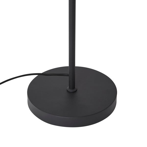 Runder, schwarzer Standfuß einer Stehleuchte aus Metall mit Netzkabel.