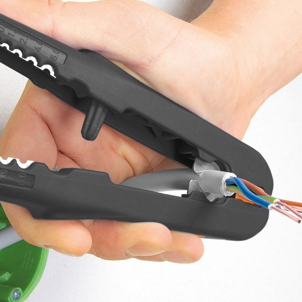 Hand nutzt schwarzen Abisolierer zum Entfernen der Isolierung eines grauen Kabels, wodurch die farbigen Adern sichtbar werden.