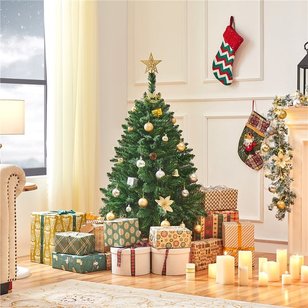 Dekoriertes Wohnzimmer mit Weihnachtsbaum, Geschenken und Weihnachtssocken am Kamin