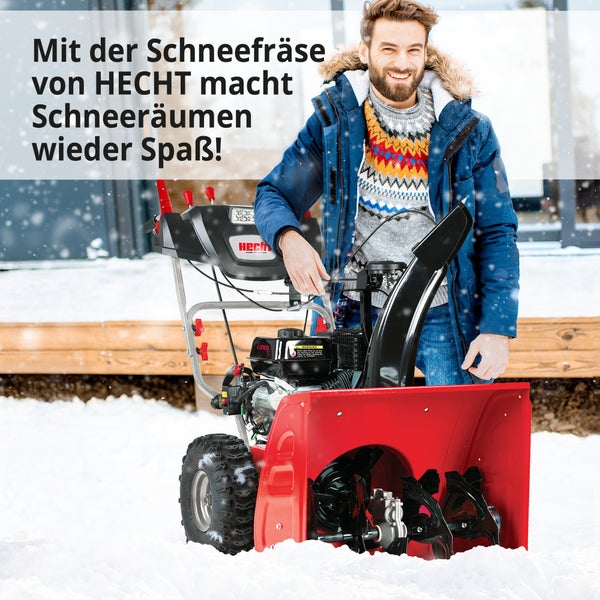 Mann mit einer roten Schneefräse von Hecht im Schnee.