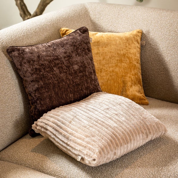 Dekorative Kissen aus verschiedenen Materialien auf einem Sofa