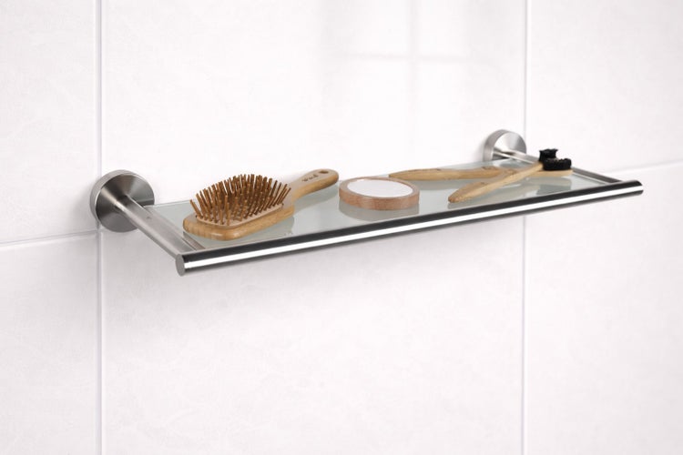 Glasablage für das Badezimmer mit Metallhalterung, bestückt mit Haarbürste und Zahnbürsten.