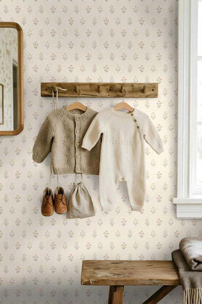 Vliestapete mit kleinem Blumenmuster in einem Kinderzimmer mit rustikaler Holzgarderobe und Strickkleidung.