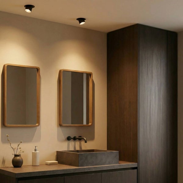Modernes Badezimmer mit zwei Holzspiegeln, schwarzen Deckenstrahlern, einem Steinwaschbecken und dunklen Holzmöbeln.