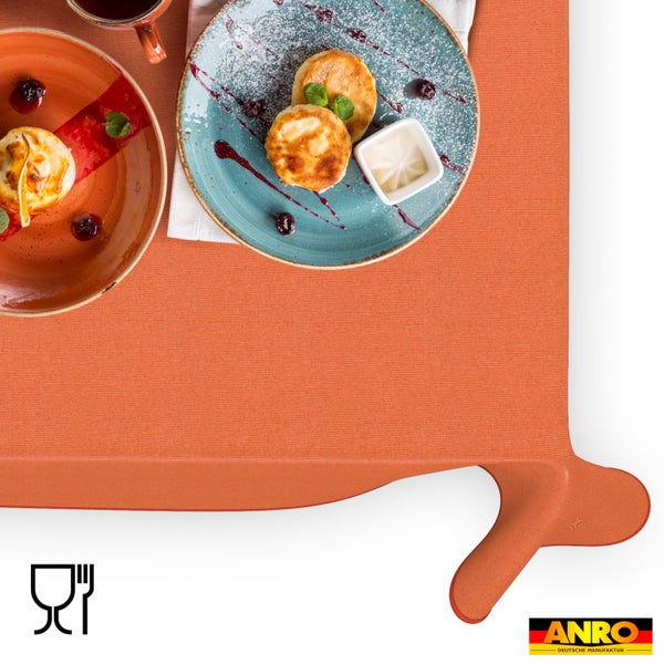Strukturierte orange Tischdecke mit Tellern mit Speisen, Symbol für Lebensmittelechtheit und ANRO Deutsche Manufaktur Logo.