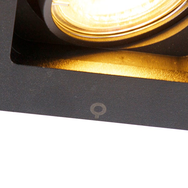 Detailansicht eines quadratischen Einbaustrahlers in Schwarz mit goldenem Innenreflektor und runder Lichtquelle.