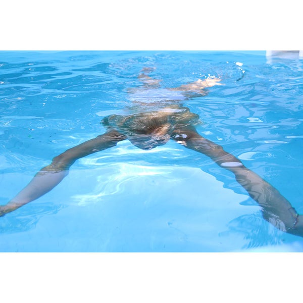 Person taucht im Schwimmbad