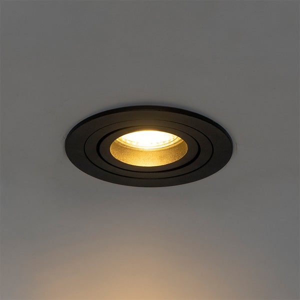 Schwarzer runder Einbaustrahler, schwenkbar, eingeschaltet mit warmem Licht.