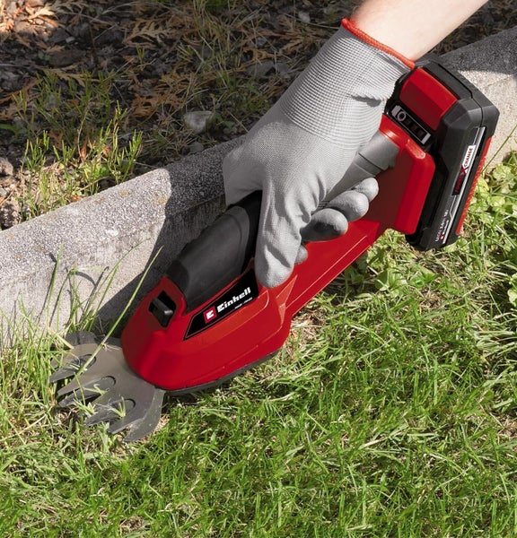 Einhell Akku-Grasschere beim Schneiden von Rasenkanten an einem Randstein aus Beton.