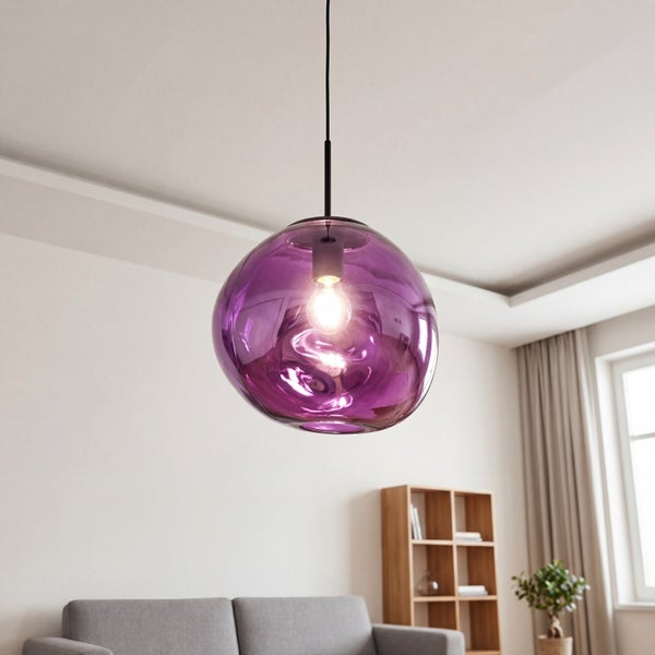 Moderne Pendelleuchte aus violettem Glas mit organischer Form in einem hellen, aufgeräumten Wohnzimmer mit grauem Sofa und Holzregal.