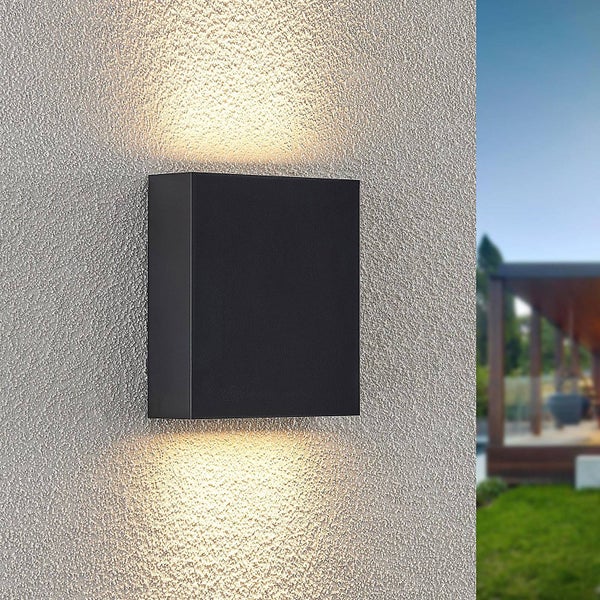 Quadratische schwarze Außenwandleuchte mit Lichtaustritt nach oben und unten an einer Fassade.