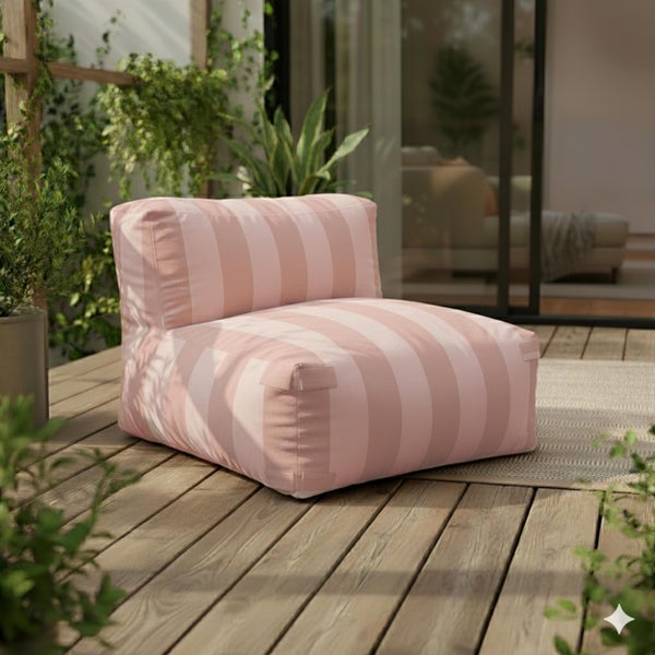 Heller Outdoor-Sitzsack mit rosa und weißen Streifen auf einer Holzterrasse mit grünen Pflanzen.