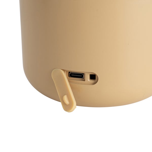 Nahaufnahme eines USB C Ladeanschlusses mit geöffneter Schutzabdeckung an einem beigefarbenen Gehäuse.