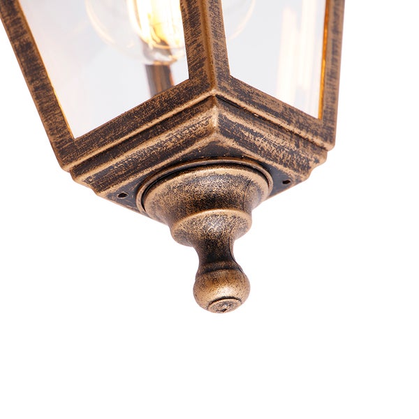 Detail einer Außenleuchte im Antik-Stil mit goldfarbener Oberfläche, Glaseinsätzen und dekorativem Abschluss.