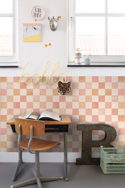 Kinderzimmer mit Schreibtisch, Stuhl und Wanddekorationen in einem hellen, organisierten Stil.