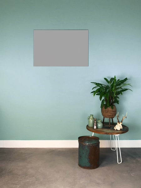 Moderner Raum, blaugrüner Wandfarbenverlauf mit grauem Platzhalter, runder Holztisch mit Pflanze und rustikaler Metallbehälter auf Betonboden.