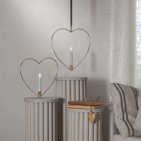 Dekorative Szene mit herzförmigen Kerzenhaltern auf Säulen