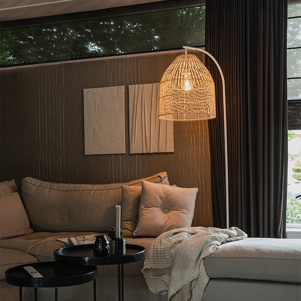 Wohnzimmer mit Sofa, Couchtisch und Stehlampe mit Lampenschirm aus Rattan