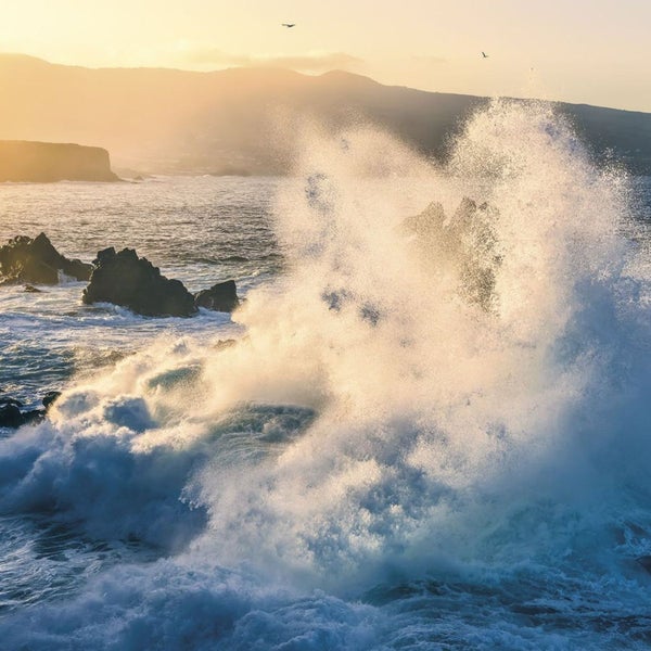 Wellen brechen an der Küste mit Felsen im Meer
