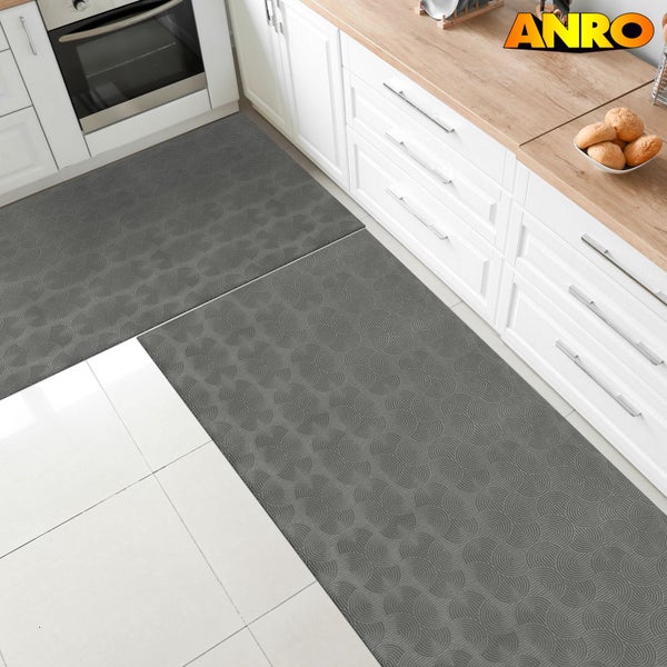 Küchenszene mit zwei grauen ANRO-Küchenläufern mit Muster vor weißen Küchenschränken.