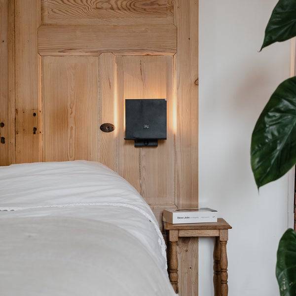 Schlafzimmer mit Bett, Nachttisch und Wandleuchte