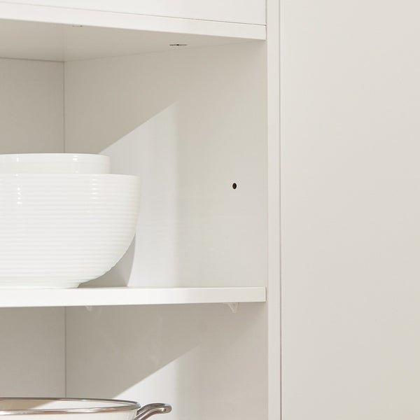 Innenansicht eines weißen Schranks mit Regalen und Geschirr