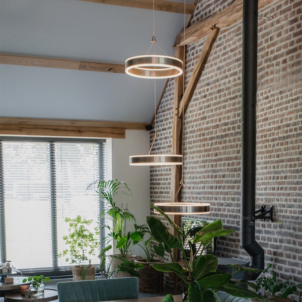 Wohnraum mit Backsteinwand und drei runden Hängeleuchten