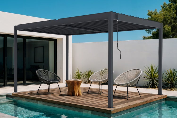 Freistehende moderne Lamellenpergola aus Metall auf einer hellen Holzterrasse am Pool mit Loungesesseln und Handkurbel.