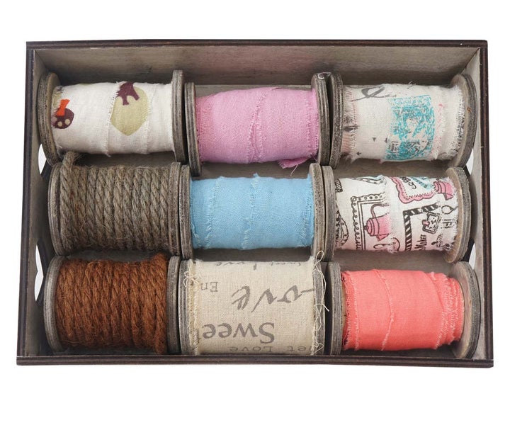 Holzkiste mit neun Spulen dekorativer Stoffbänder