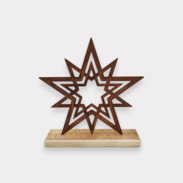 Dekorativer Stern aus Metall mit Edelrost Optik auf einem rechteckigen Holzsockel als Tischdekoration.
